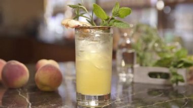 Şeftali ve biberiyeli bir bardak içki.