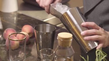 Adam bardağı alıp içine buz koyuyor.