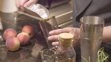 Adam bardağa buz dolduruyor.