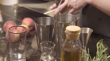 Adam zencefilden gümüş bardağa şerbet döküyor.