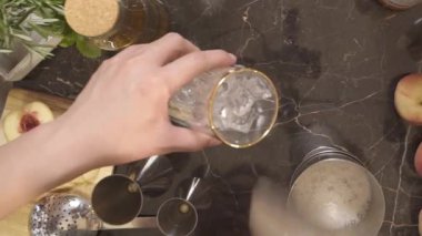 Küçük bir bardağa buz koyan adam.