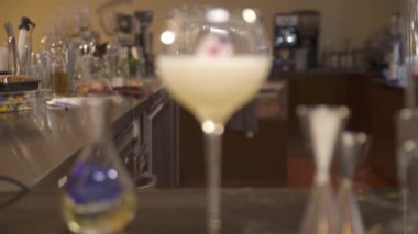 a glass drink with flowers on the table - static rack focus