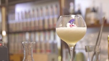  a glass drink with flowers on top - static