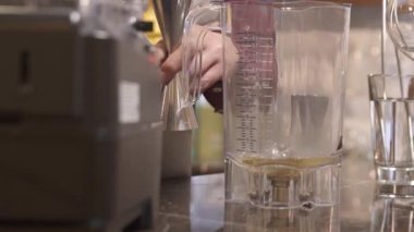 Adam jigger tutuyor ve blender 'a döküyor. 