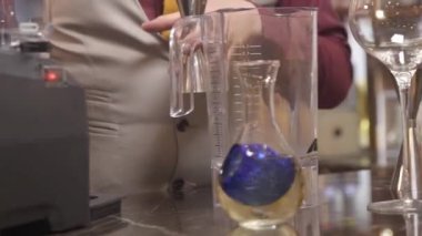 Adam blendere şurup döküyor.