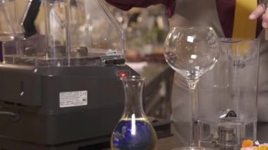 Adam cam karıştırıcıya şurup döküyor.