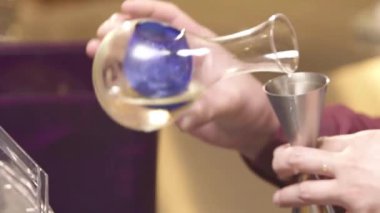 Adam şerbeti blendere döküyor. 