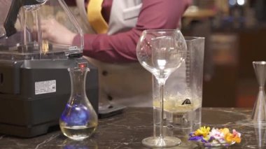 Adam miksere bir kepçe buz dolduruyor.