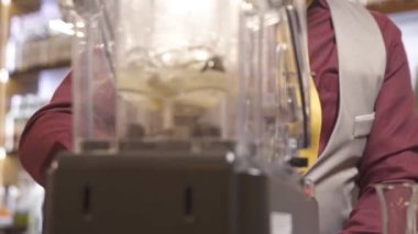 Makinedeki blenderi kullanan adam. 