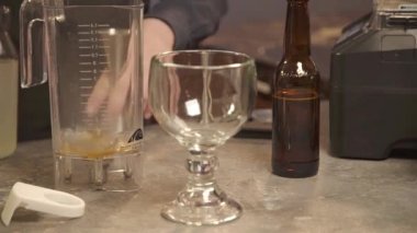 Eller yukarıdan miksere bir içki dolduruyor - statik.