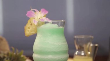 Drink with pineapple and flower petal on board - pedestal up.
