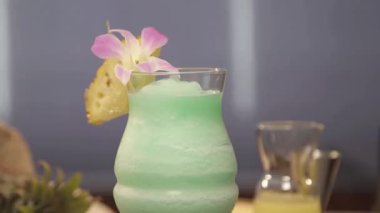 Drink with pineapple slice and flower petal on board - pedestal down