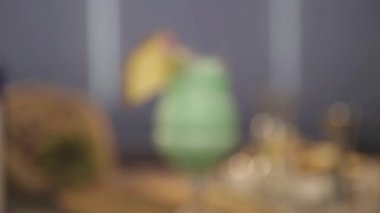 Üzerinde ananas dilimi ve taç yaprağı olan yeşil renkli bir içecek. 