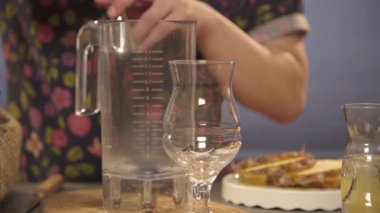 Adam jigger içine şurup döküyor sonra karıştırıcı için