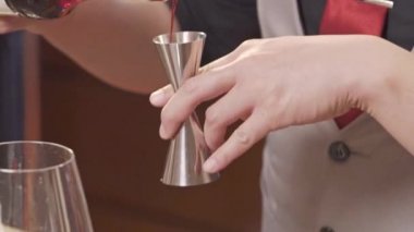 Şişeden jigger 'a şurup dökülüyor.