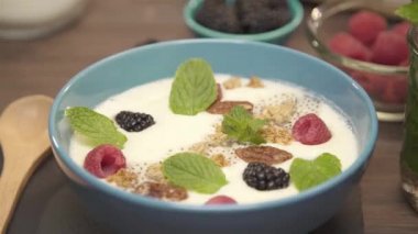 Mavi kase ahşap kaşıkla kavanoz arasında.