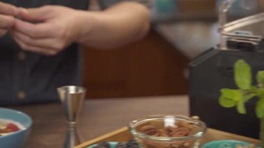 Adam kavanozda nane yaprağı topluyor.