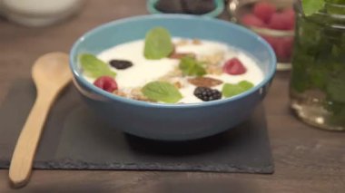 Mavi kasenin içindeki meyveli buzlu içecek.
