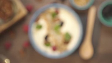 Ahşap kaşığın üst görüntüsü bir kase smoothie 'nin yanında - rafa odaklanma.