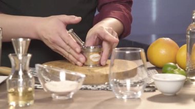 Kahveci doğrama tahtasının üzerinde gümüş bir kavanoz çeviriyor.