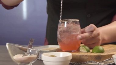 Kahveci bardakta kaşıkla içki karıştırır.