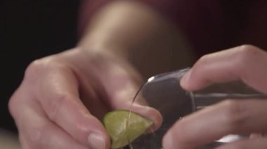 Cam bardağa limon suyu dökerek.