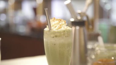 Metal kamış ve kremalı bir içecek.