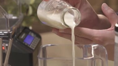 Karıştırıcıya bir şişe süt döküyorum.