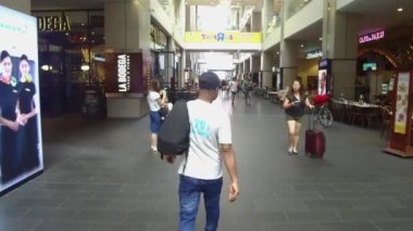 Elinde çanta olan bir adam etrafa bakıyor.