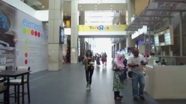 İnsanlar yan taraftaki yemek standının önünden geçiyorlar.