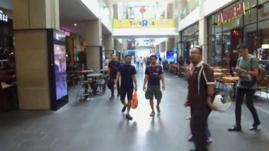 İnsanlar dükkanlarda dolaşıyor ve etrafa bakınıyor