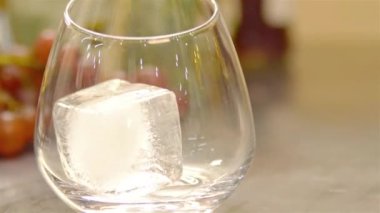 Bardağı tut, buz küpünü koy ve içkiyi doldur.