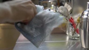 Eller tereyağı bıçağını kuru bezle siliyor.