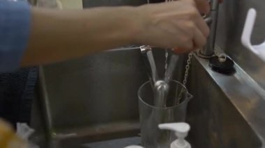 Cam bardak ve çatal bıçak tutan bir adam.