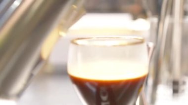 Su kadehe yavaşça kahve döküldü.