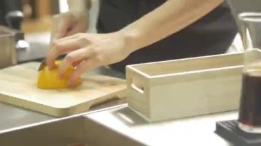 Bir dilim limonu kesen kadın.