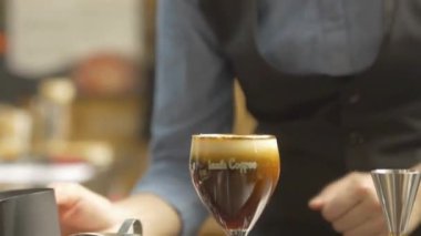 Kadın kahvenin üstüne çikolata tozu döktü.