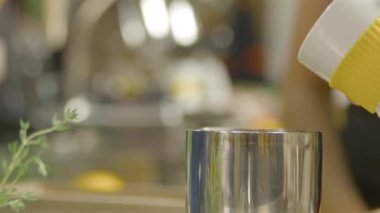 Kadın gümüş fincanın içine bir porsiyon kahve dolduruyor.