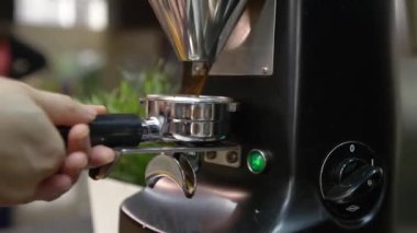 woman putting coffee machine lever and take coffee powder - pan