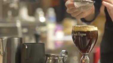 Kadın üstüne çikolata tozu serpiyor.