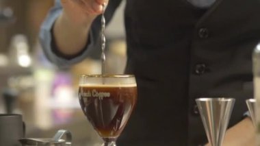 Gümüş kaşıkla içki karıştıran kadın