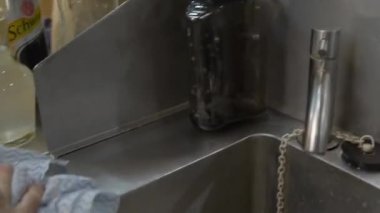 Lavaboyu mavi bir bezle silen kadın.