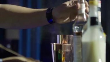 Adam masadan bir bardak şişe alıyor.