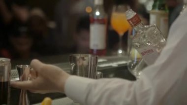 Adam içkiyi jigger 'a döker ve sallar.