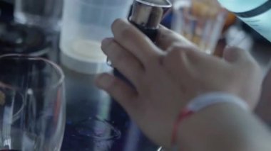 Jigger 'ın içindeki içkileri dolduran el. Sonra cam.