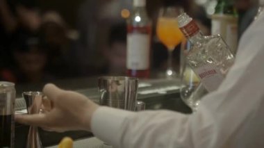 Adam içkiyi jigger 'a döker ve sallar. 