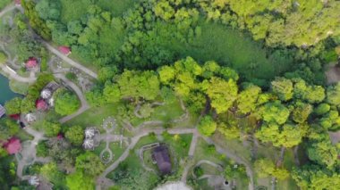 Top view of park, hills and silhouette of mountain in the distance - Tilt up.