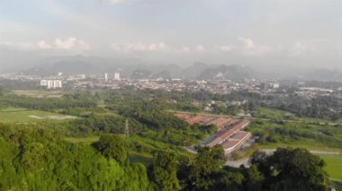 View of hills and city with mist covered mountain - Pan left - Dolly Backwards