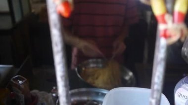 Bir kase eriştenin önünde iki adam. Sola kay..