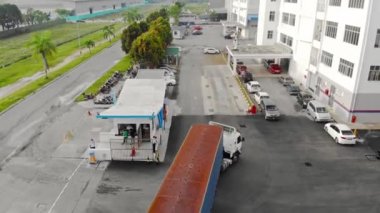 Gardiyan evinden otoparka bir kamyon geliyor, yukarıdan iniyor.